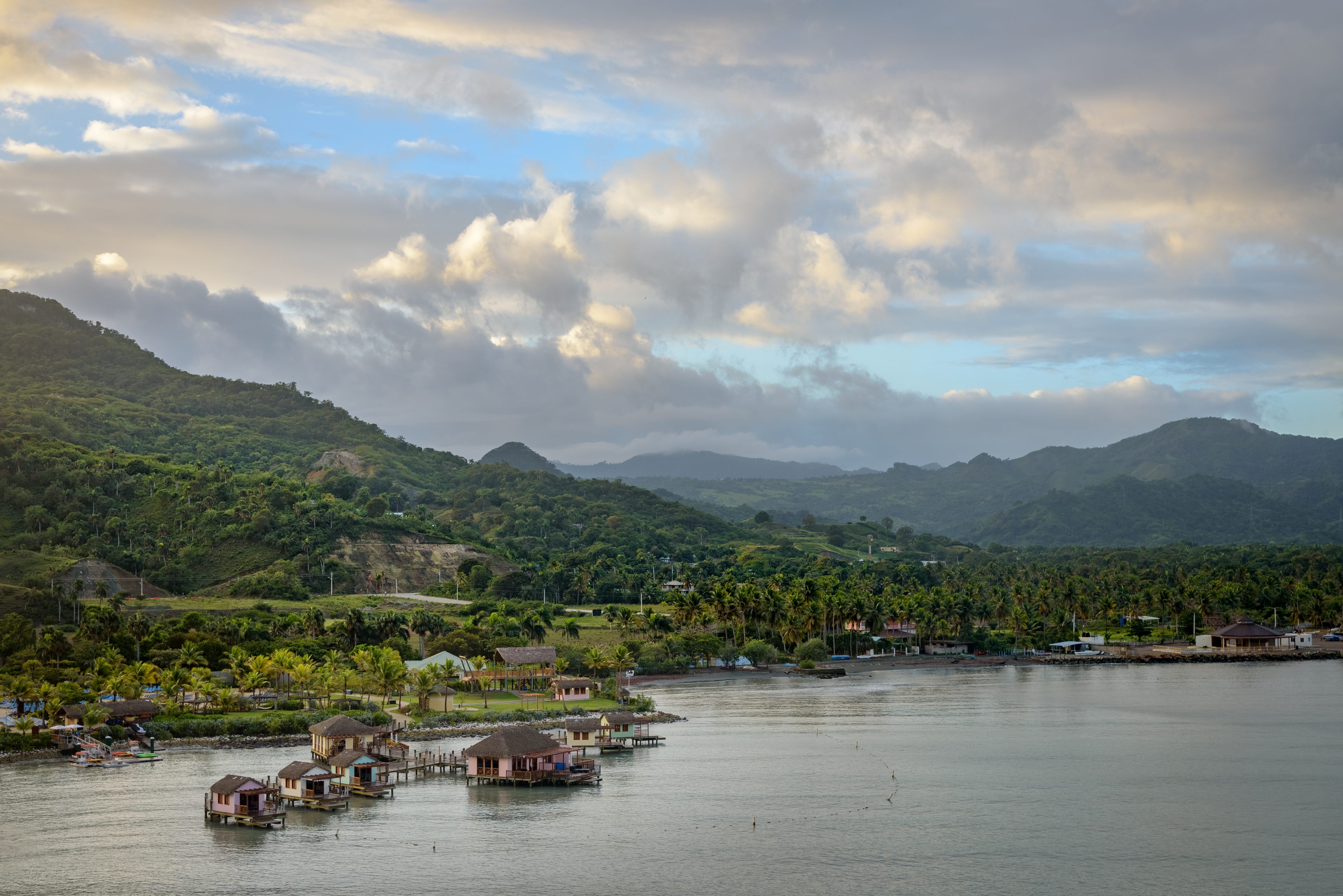 Amber Cove on the Bay of Maimón, with overwater huts and hills behind
