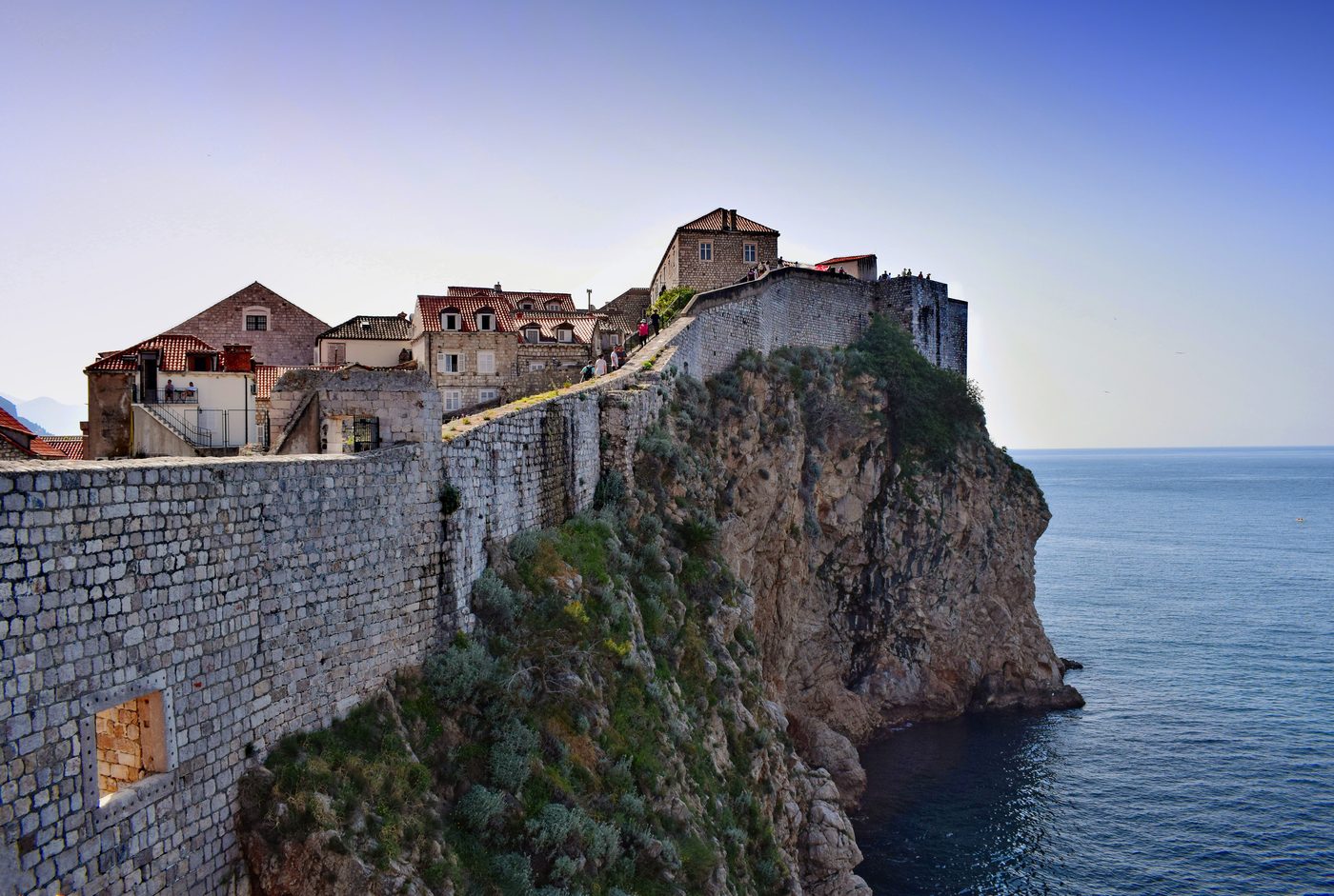 Walkers on the Dubrovnik city wall beside the sea