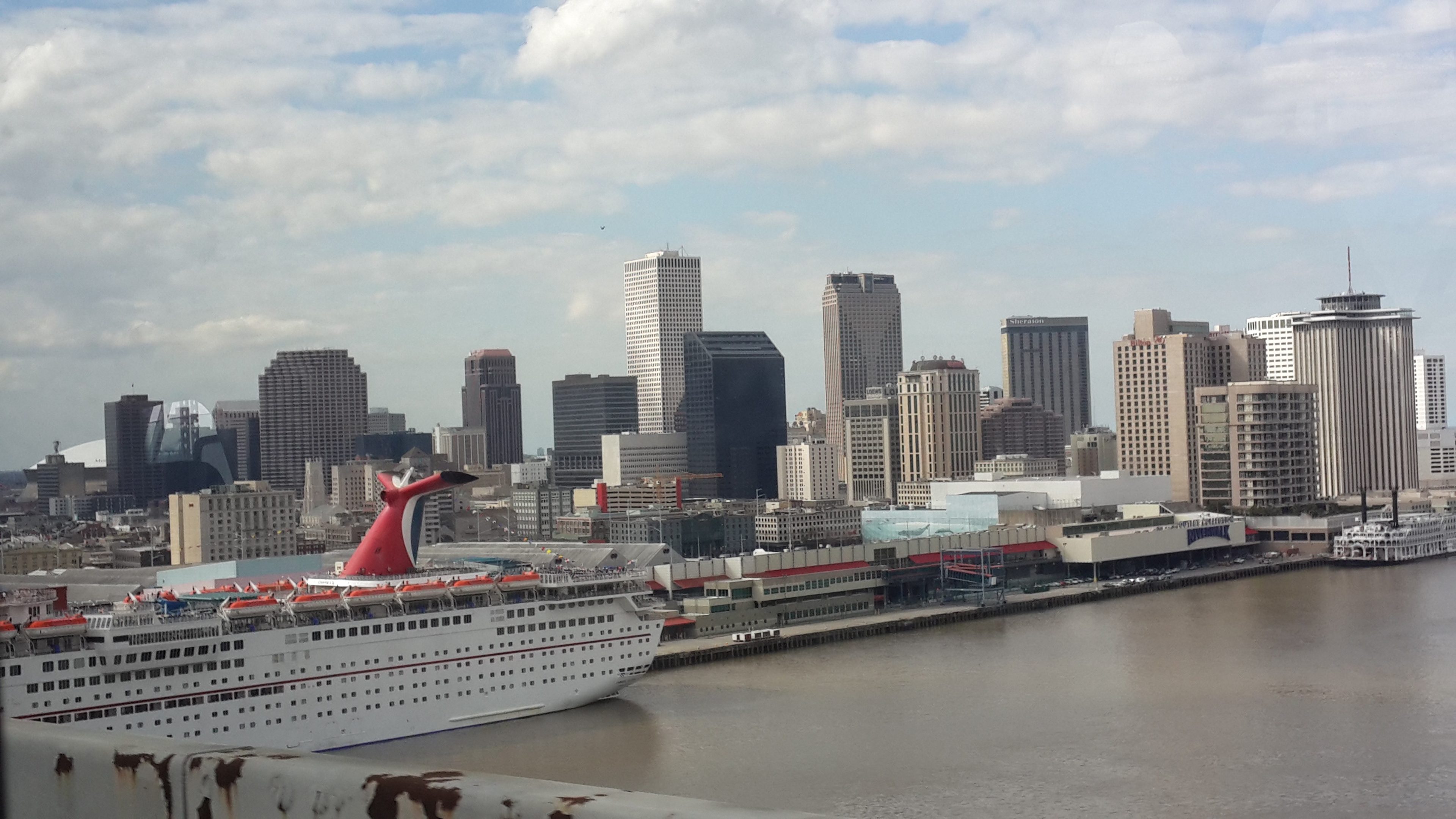 The New Orleans skyline seen from the Crescent City Connection bridge, with a cruise ship at the pier