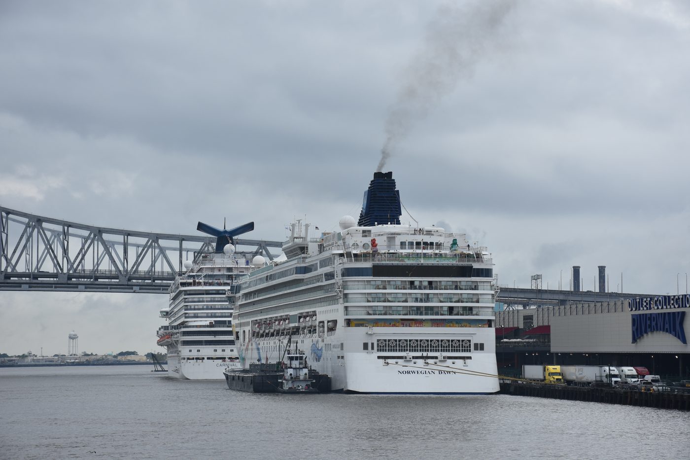 Cruise ships docked on the Mississippi River in New Orleans with the Crescent City Connection behind